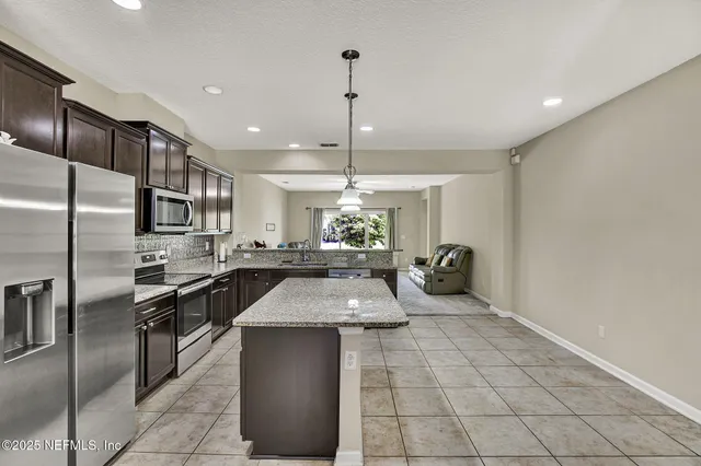 a kitchen with granite countertop a sink stainless steel appliances and cabinets