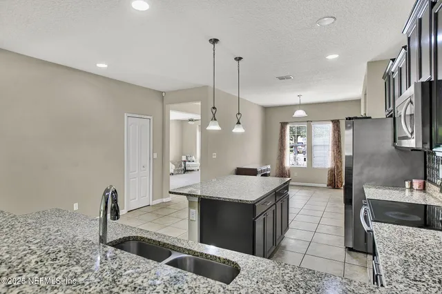 a kitchen with stainless steel appliances kitchen island granite countertop a sink and a stove