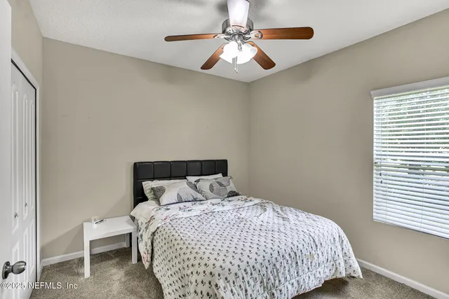 a bedroom with a bed and a ceiling fan