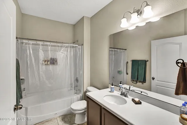a bathroom with a bathtub shower sink vanity and toilet