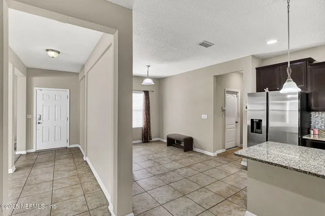 a view of a hallway with entryway and kitchen view
