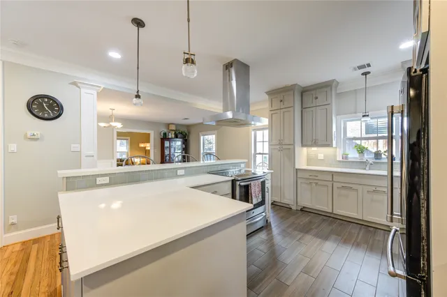 a large kitchen with kitchen island a large counter top space a sink stainless steel appliances and cabinets