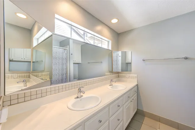 a bathroom with a double vanity sink mirror and bathtub
