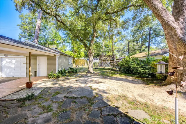 a view of a house with backyard and a tree