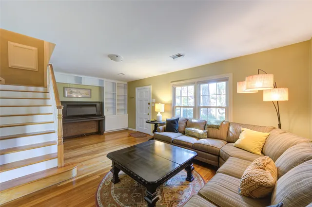 a living room with furniture and wooden floor