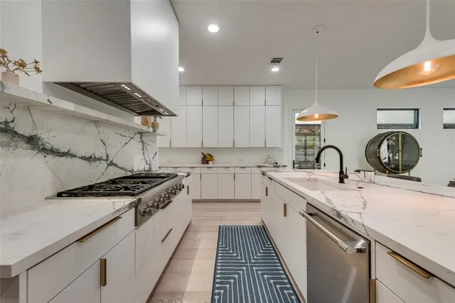 a kitchen with stainless steel appliances granite countertop a sink stove and cabinets