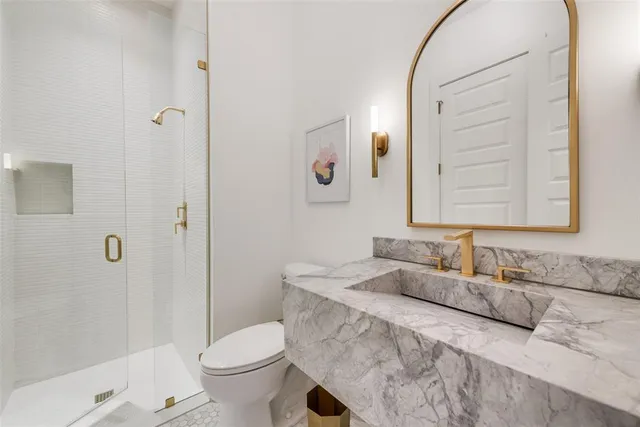 a bathroom with a granite countertop sink toilet and shower
