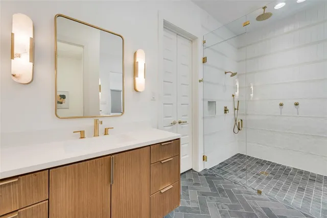 a bathroom with a double vanity sink mirror and shower