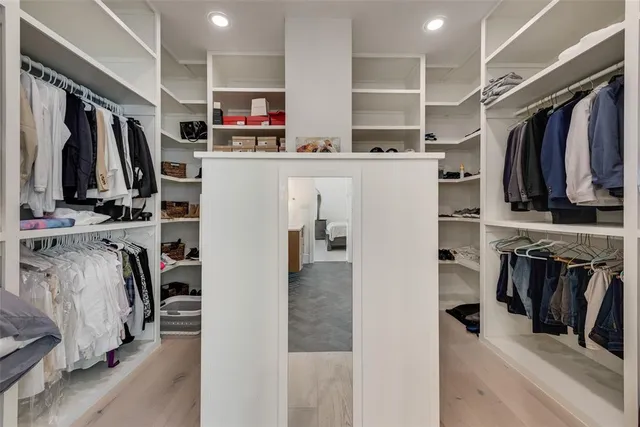 a view of walk in closet with clothes and shoes