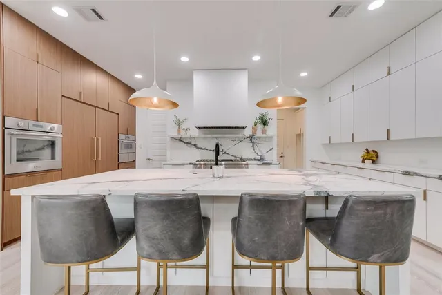 a kitchen with stainless steel appliances granite countertop a sink and a refrigerator