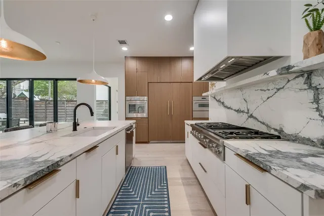 a kitchen with granite countertop a sink stainless steel appliances and cabinets