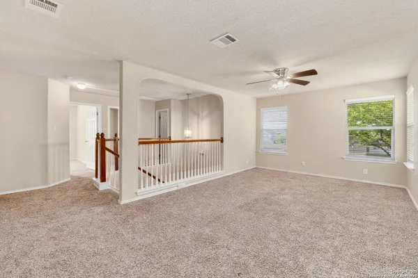 an empty room with windows and fan