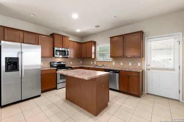 a large kitchen with stainless steel appliances granite countertop a stove a sink dishwasher and a refrigerator