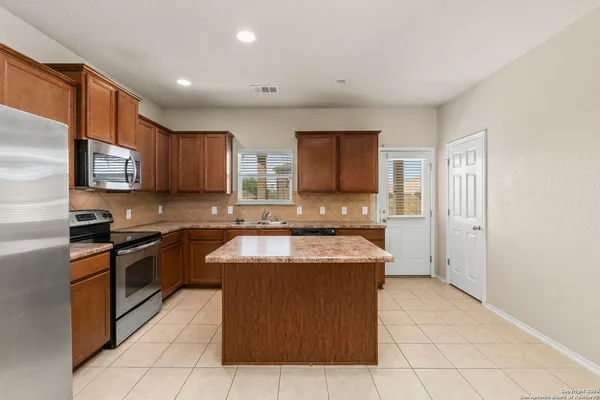 a kitchen with stainless steel appliances granite countertop a stove a sink a microwave and a refrigerator