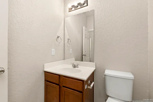 an empty room with windows and fan chandelier