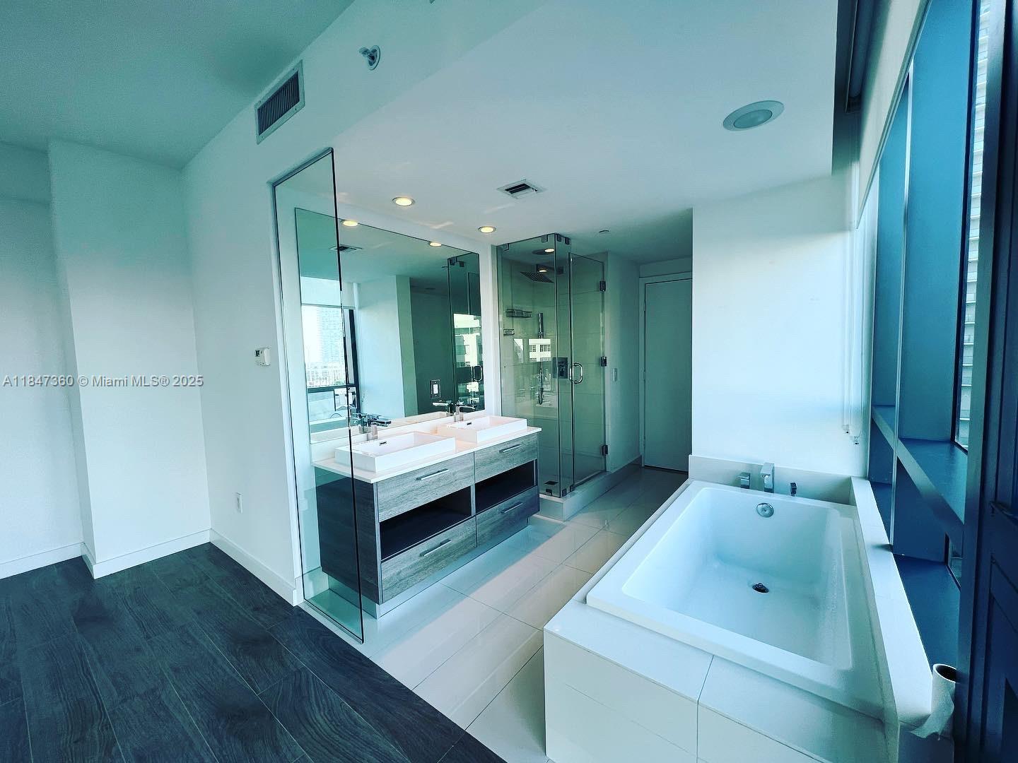 650 Northeast 32nd Street, Unit 3508 Miami, FL 33137 - Photo 6 of 13 a bathroom with a sink mirror and tub