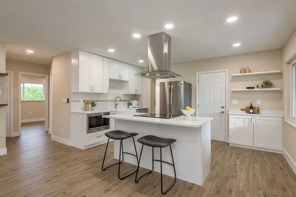 a kitchen with a sink a refrigerator and cabinets