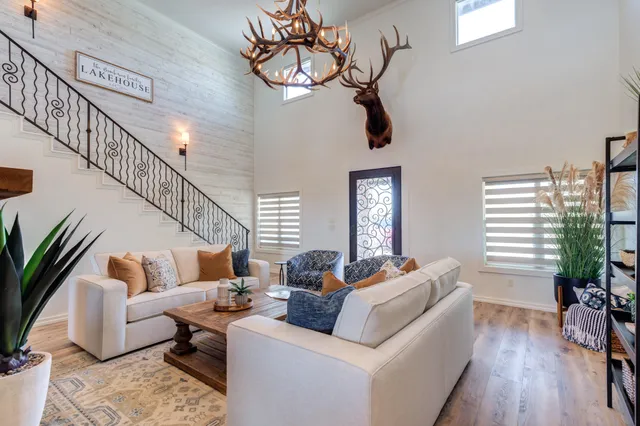 a living room with furniture a clock and a potted plant