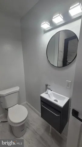 a bathroom with a sink mirror and toilet