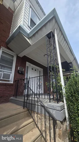 a view of house with staircase and outdoor seating