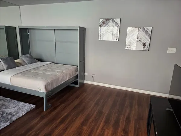 a bed sitting in a bedroom and wooden floor