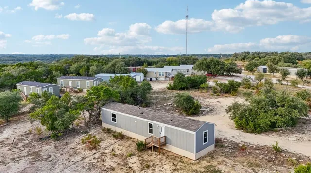an aerial view of a house with a yard and lake view
