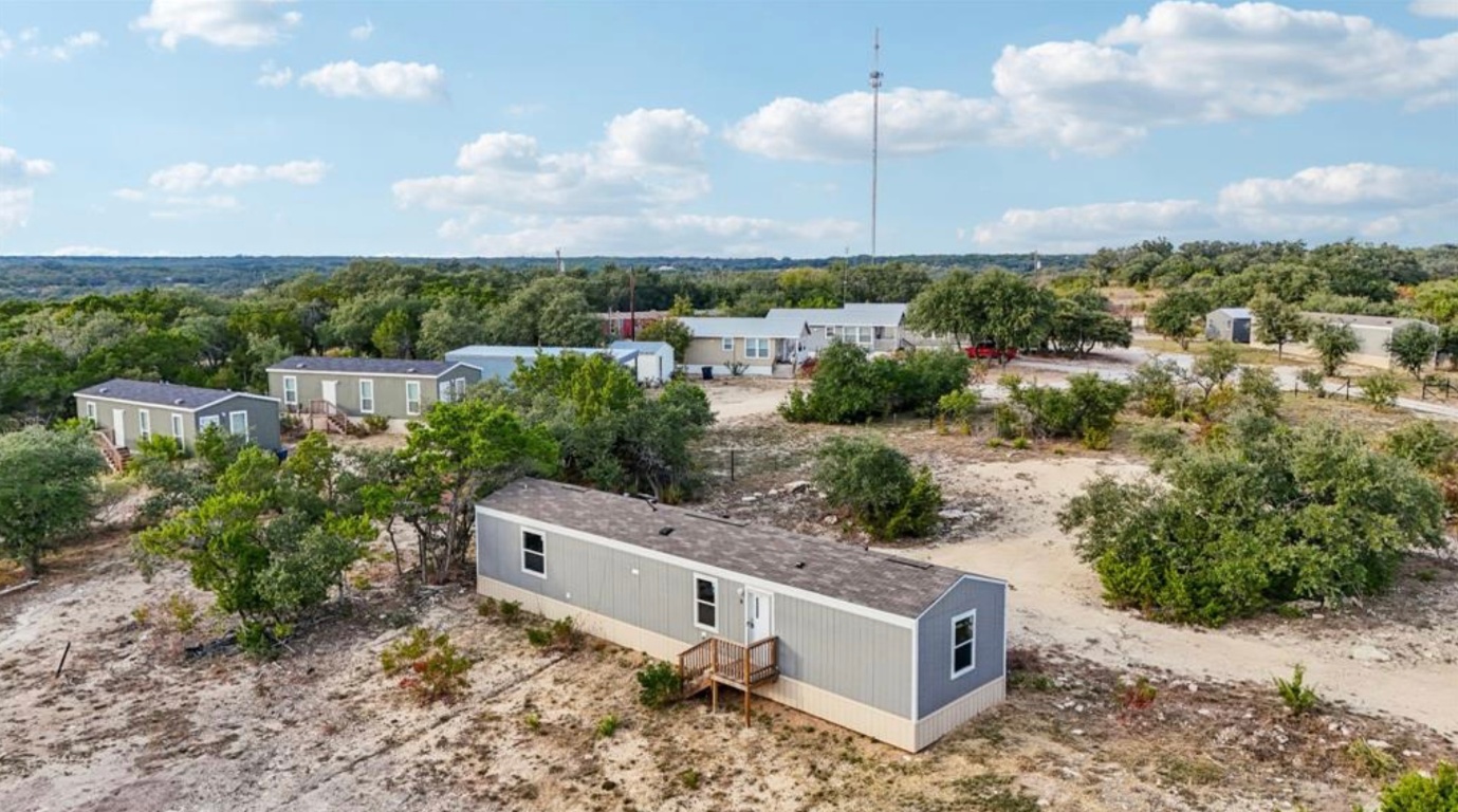 an aerial view of a house with a yard and lake view