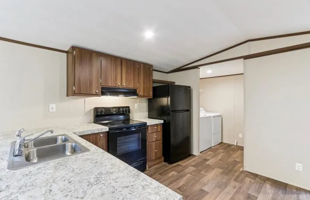 a kitchen with stainless steel appliances granite countertop a refrigerator sink and stove