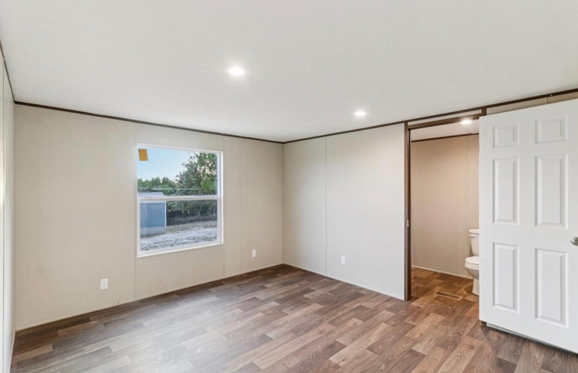 24369-2 Bingham Creek Road, Unit 1 Leander, TX 78641 - Photo 8 of 17 a view of an empty room with wooden floor and a window