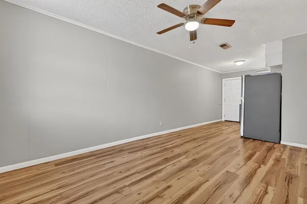 an empty room with wooden floor a ceiling fan and closet