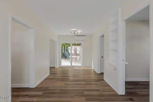 a view of an empty room with wooden floor