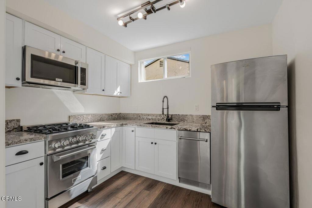 6131 Ranchito Avenue Los Angeles, CA 91401 - Photo 7 of 12 a kitchen with stainless steel appliances granite countertop a refrigerator stove a sink and dishwasher with wooden floor