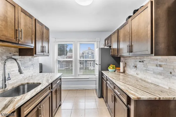 a kitchen with granite countertop a sink a stove and wooden cabinets