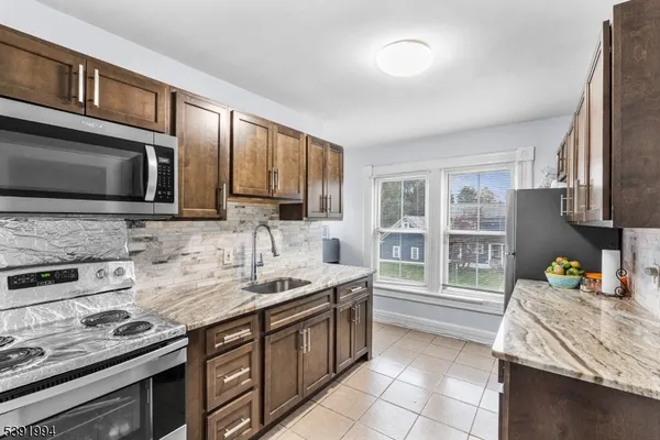 a kitchen with stainless steel appliances a stove sink microwave and cabinets