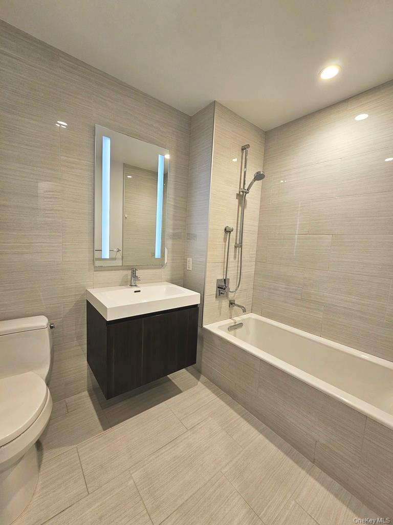 131-03 40 Road, Unit PH1Y Queens, NY 11354 - Photo 7 of 13 a bathroom with a bathtub shower sink mirror and toilet