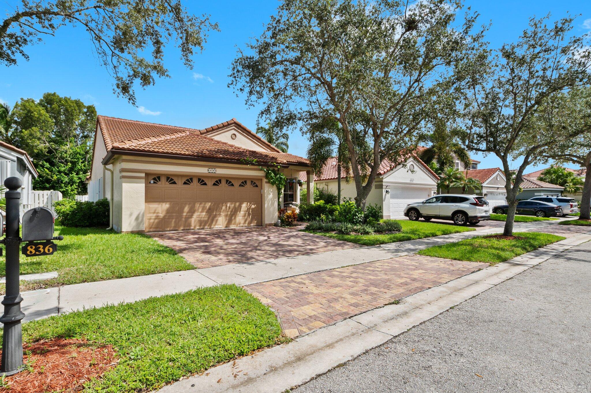 836 Falling Water Road Weston, FL 33326 - Photo 3 of 37 a front view of a house with a yard and garage
