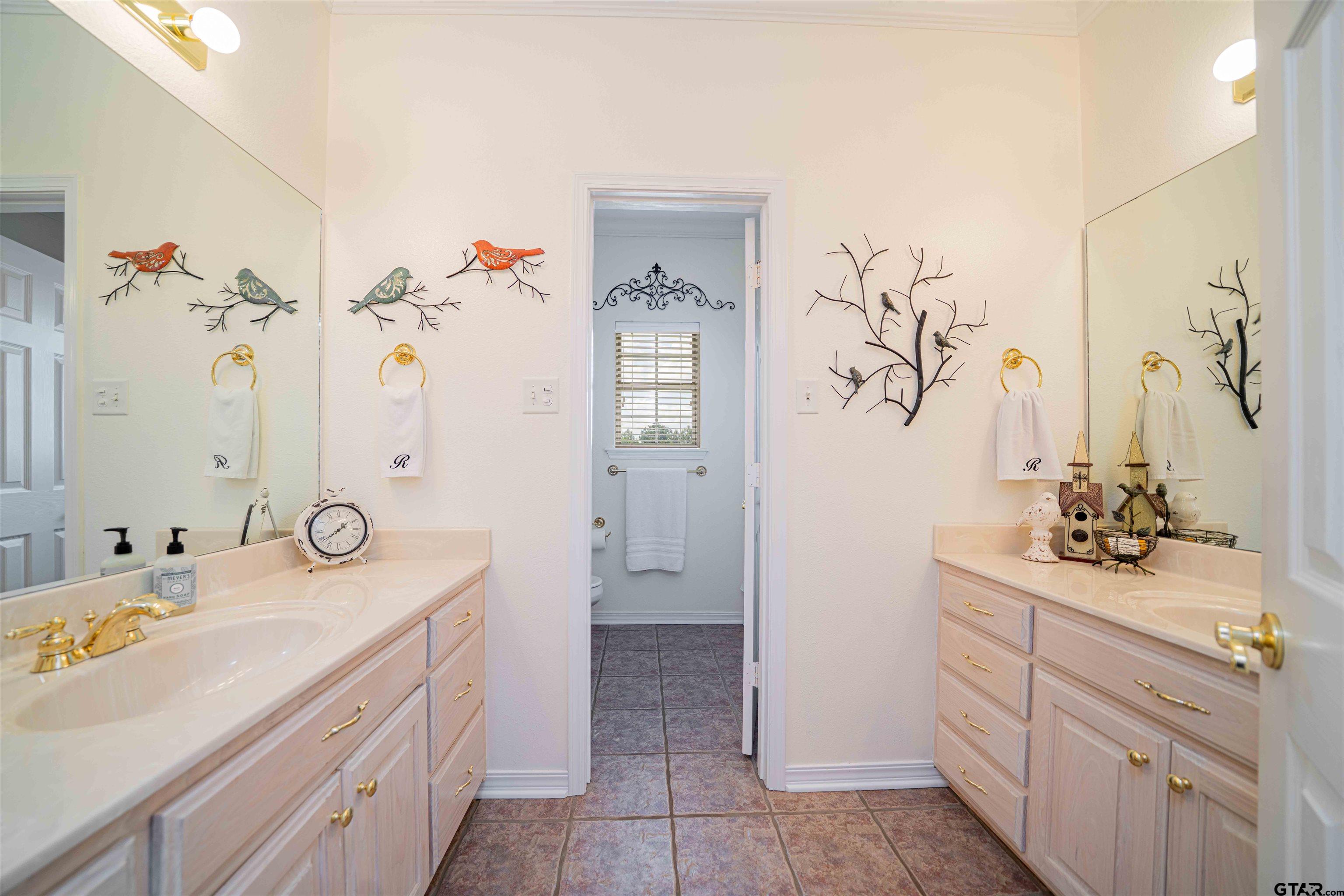 1855 Phillips Springs Road Gladewater, TX 75647 - Photo 12 of 36 a bathroom with a double vanity sink and mirror