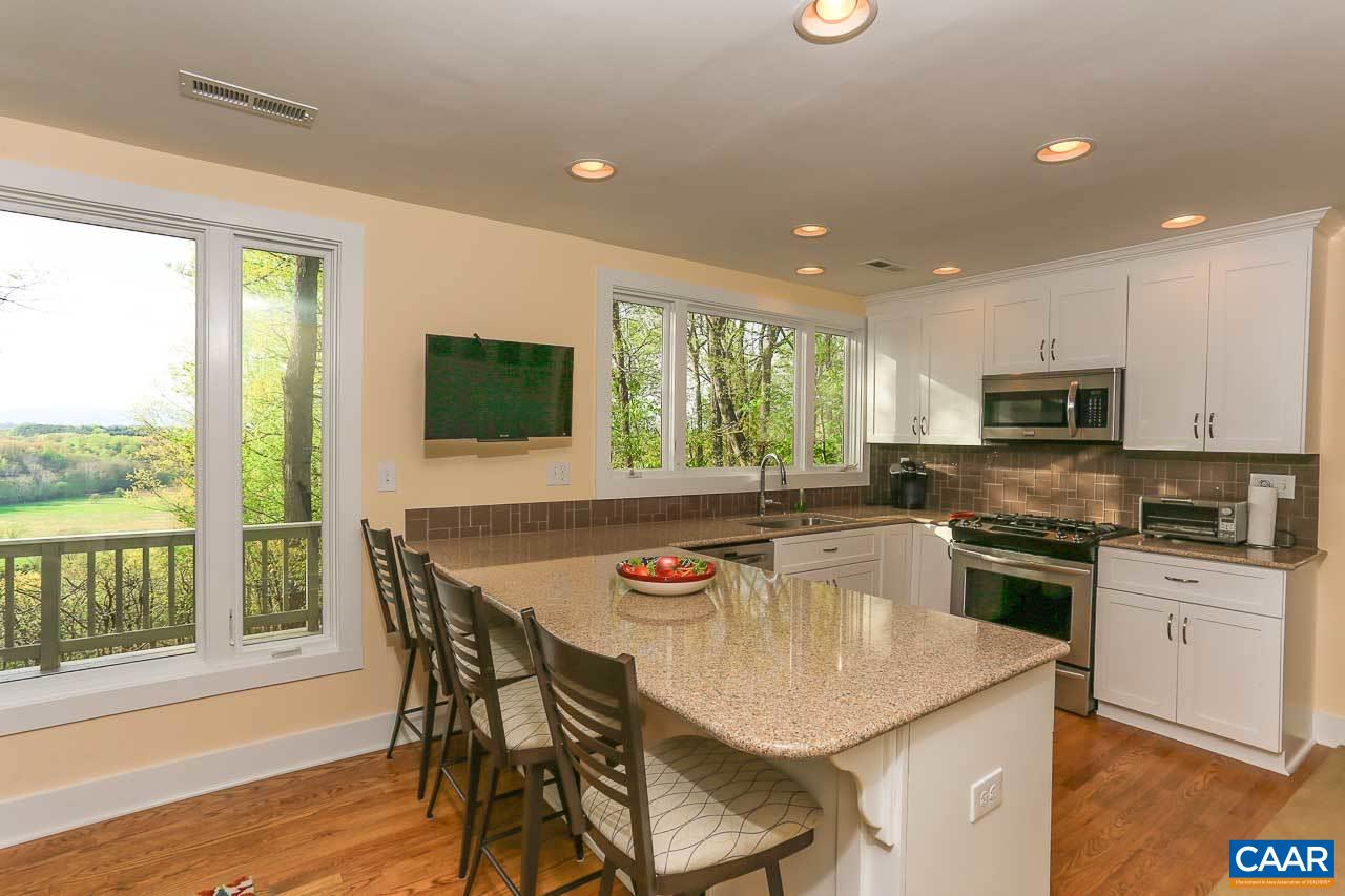 590 Explorers Road Charlottesville, VA 22911 - Photo 10 of 50 a kitchen with stainless steel appliances granite countertop a stove a sink a microwave a dining table and chairs