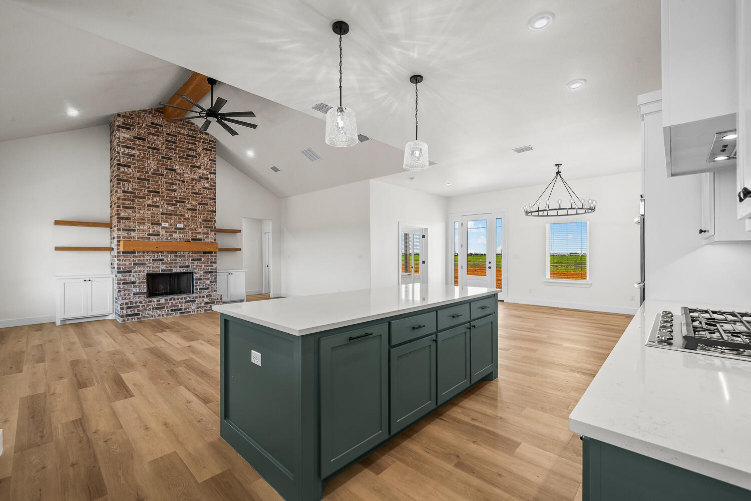 8115 County Road Shallowater, TX 79363 - Photo 17 of 47 a spacious kitchen with stainless steel appliances granite countertop a sink dishwasher a living room with fireplace and wooden floor