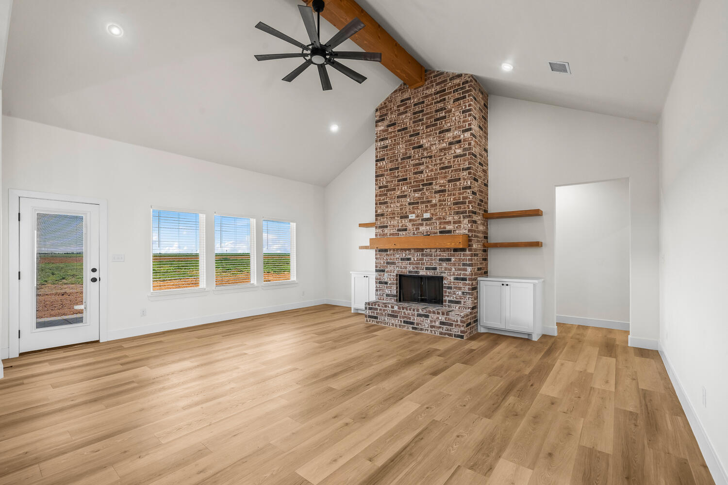 8115 County Road Shallowater, TX 79363 - Photo 27 of 47 wooden floor in an empty room with a fireplace