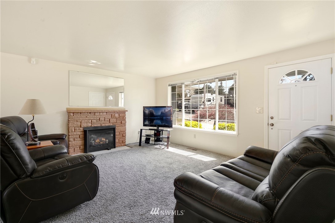 3322 Northeast 10th Place Renton, WA 98056 - Photo 4 of 21 a living room with furniture a flat screen tv and a fireplace