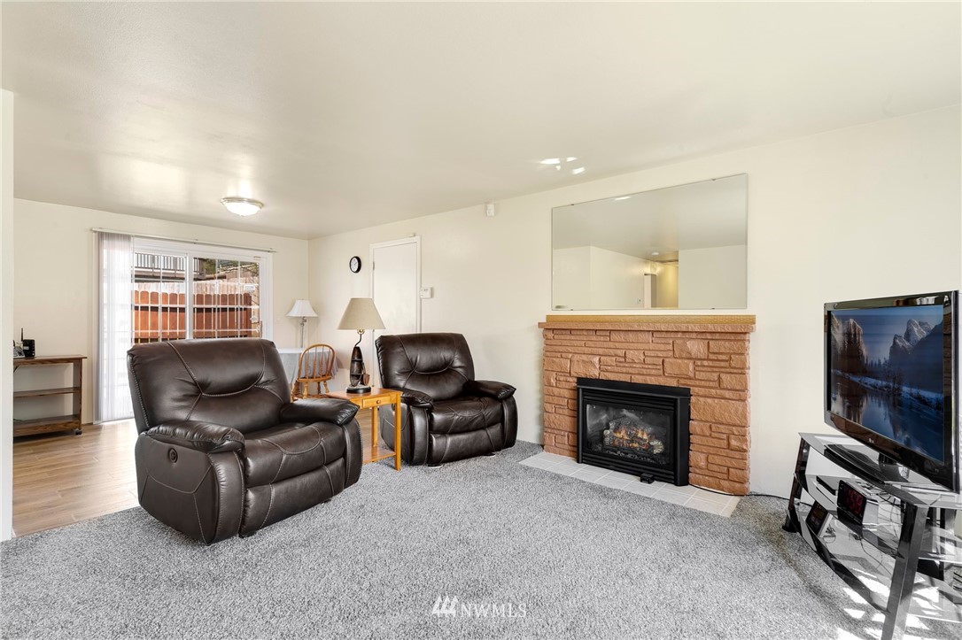 3322 Northeast 10th Place Renton, WA 98056 - Photo 5 of 21 a living room with furniture a fireplace and a flat screen tv