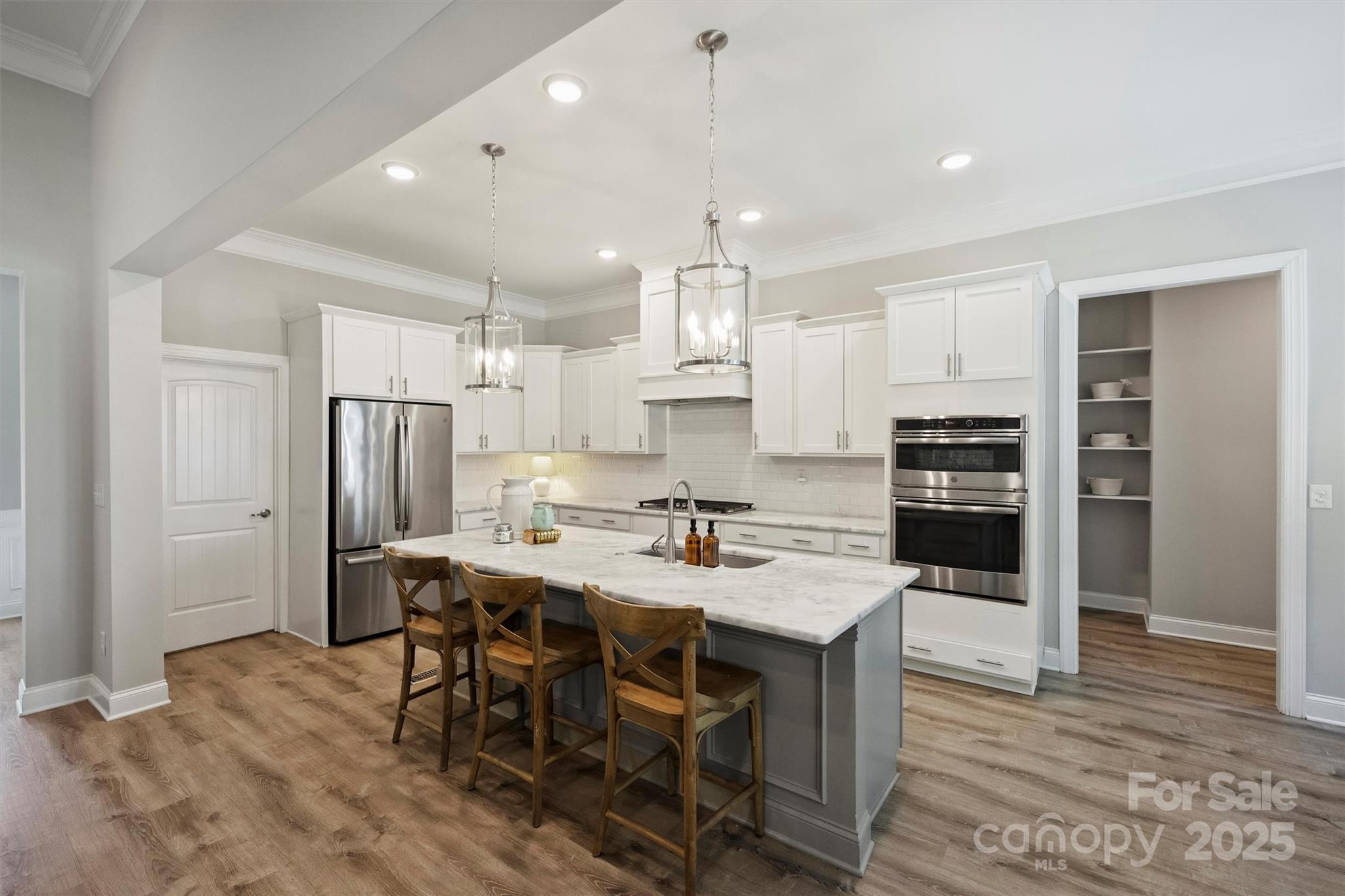 2413 Rocky River Road Charlotte, NC 28213 - Photo 5 of 46 a kitchen with stainless steel appliances a dining table chairs stove refrigerator and cabinets