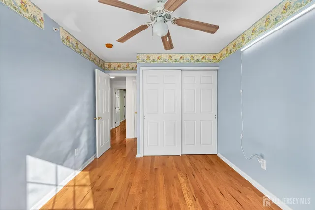 a view of a room with wooden floor and ceiling fan