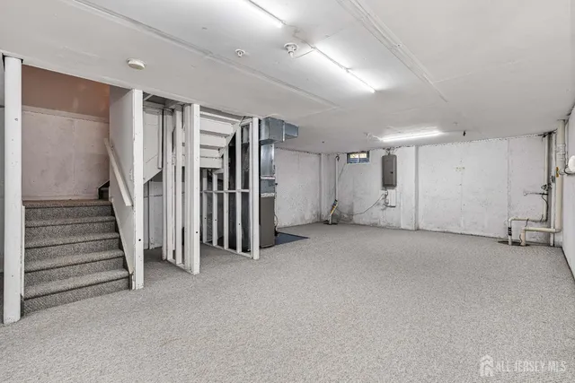 a view of an empty room with stairs and a furniture