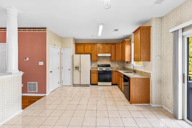 a kitchen with stainless steel appliances granite countertop a refrigerator and a stove top oven