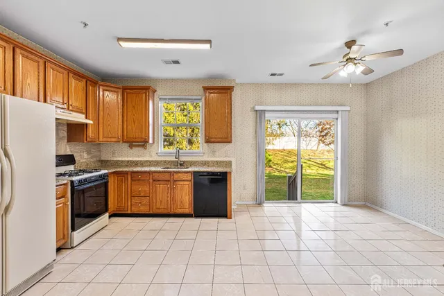 a kitchen with stainless steel appliances granite countertop a stove a sink and a refrigerator