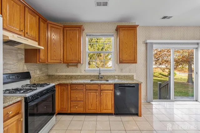 a kitchen with stainless steel appliances granite countertop a stove a sink and a microwave