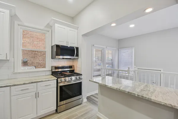 a kitchen with granite countertop a stove and a sink