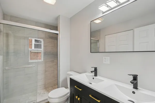 a bathroom with a sink a toilet and shower